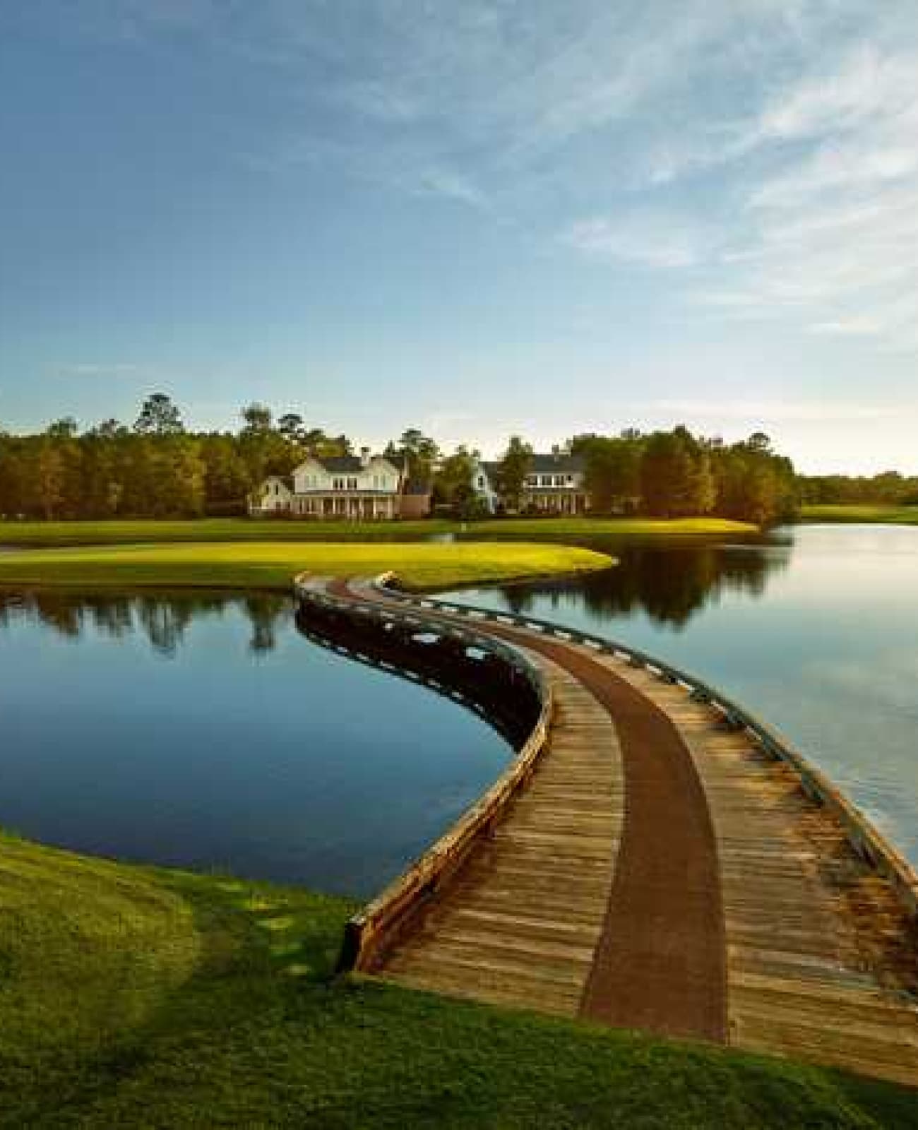 Scenic view of a golf course with a bridge over water.