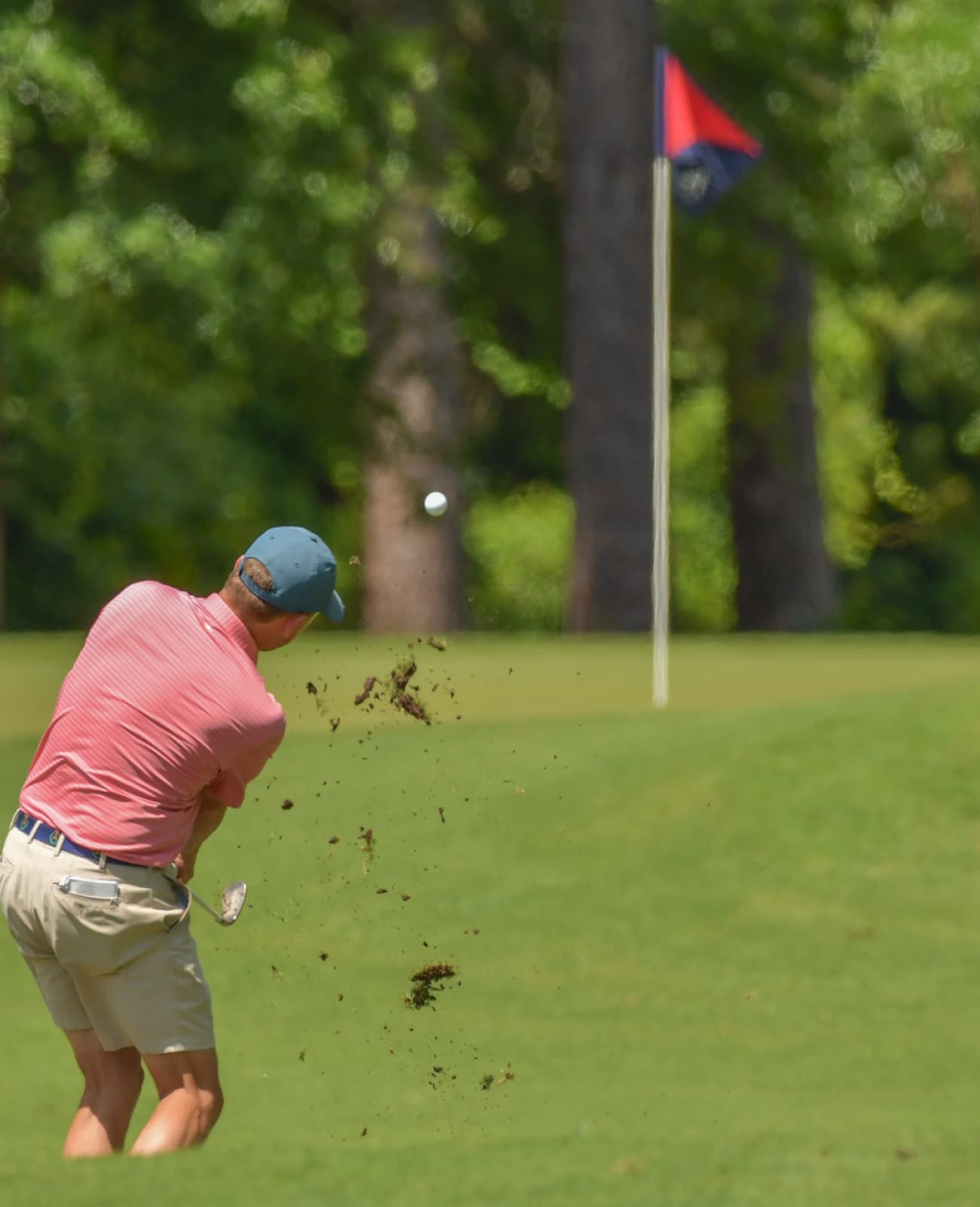 Male golfer chipping toward the putting green