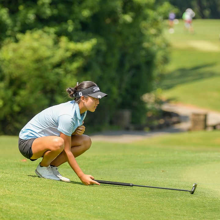 a golfer assessing her putt