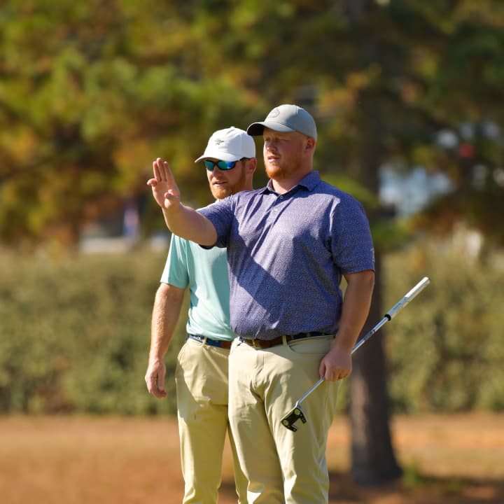 two male golfers lining up their next shot